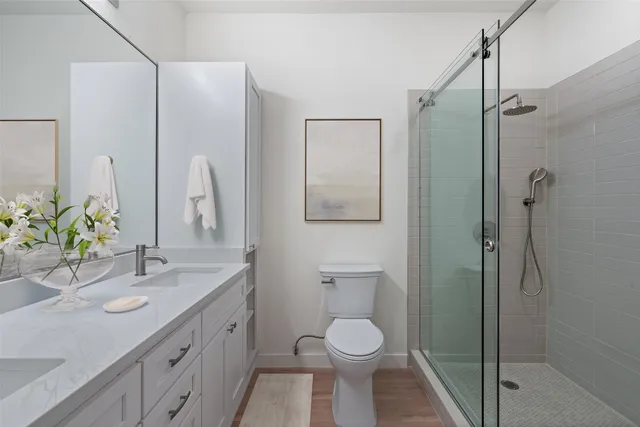 a bathroom with a sink a toilet and shower