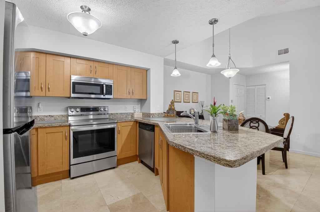 3237 Clint Moore Road, Unit 206 Boca Raton, FL 33496 - Photo 11 of 49 a kitchen with sink a microwave and cabinets