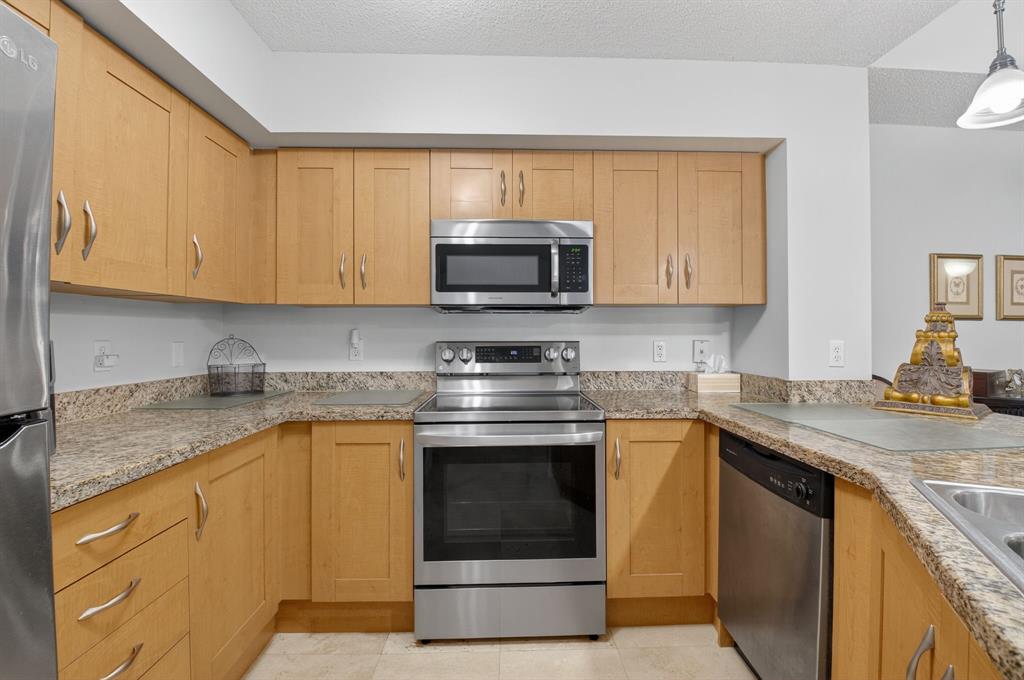 3237 Clint Moore Road, Unit 206 Boca Raton, FL 33496 - Photo 12 of 49 a kitchen with stainless steel appliances granite countertop a stove a sink and a microwave