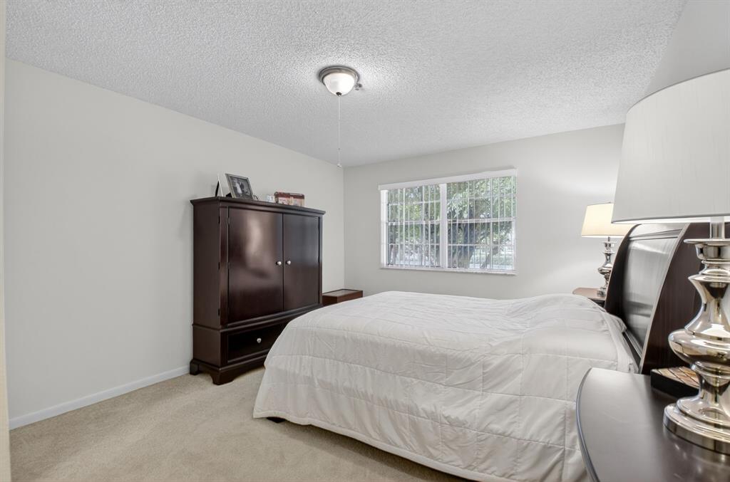 3237 Clint Moore Road, Unit 206 Boca Raton, FL 33496 - Photo 14 of 49 a bedroom with a bed and a mirror