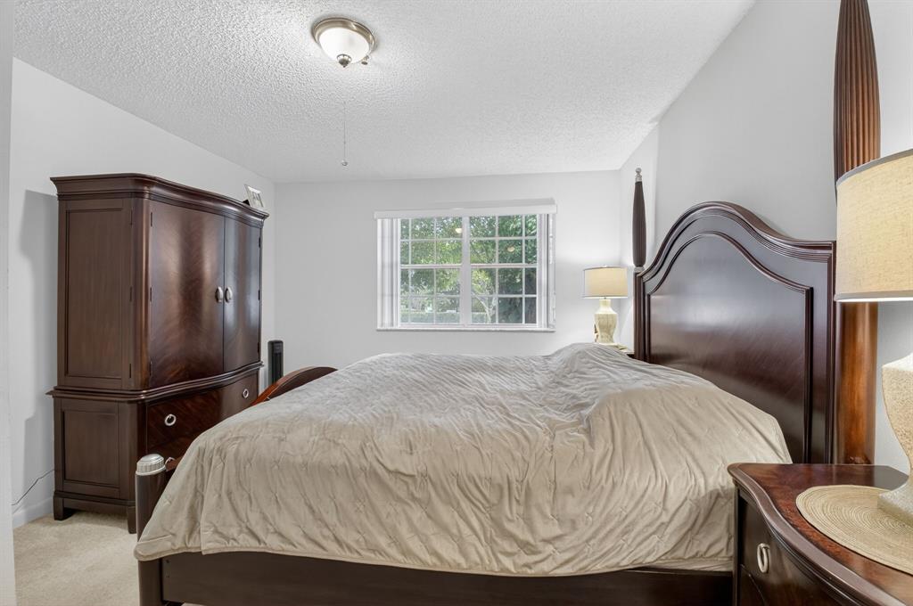 3237 Clint Moore Road, Unit 206 Boca Raton, FL 33496 - Photo 18 of 49 a bedroom with a bed and a large mirror