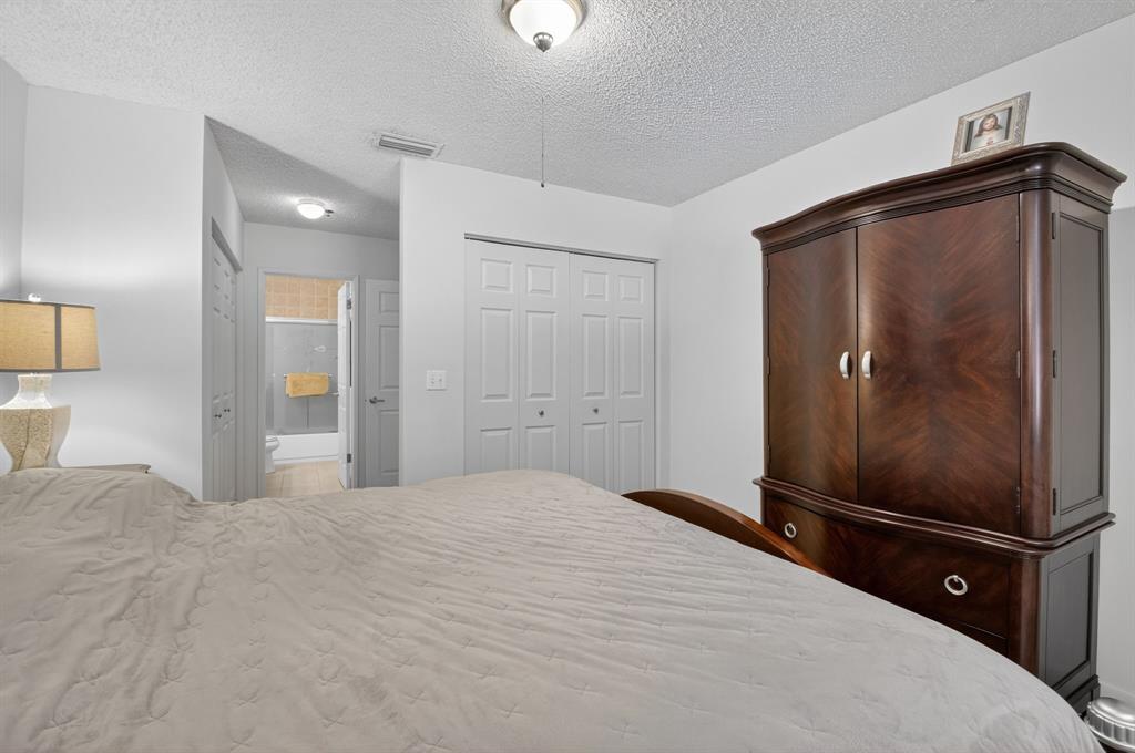 3237 Clint Moore Road, Unit 206 Boca Raton, FL 33496 - Photo 19 of 49 a bedroom with a bed and a walk in closet