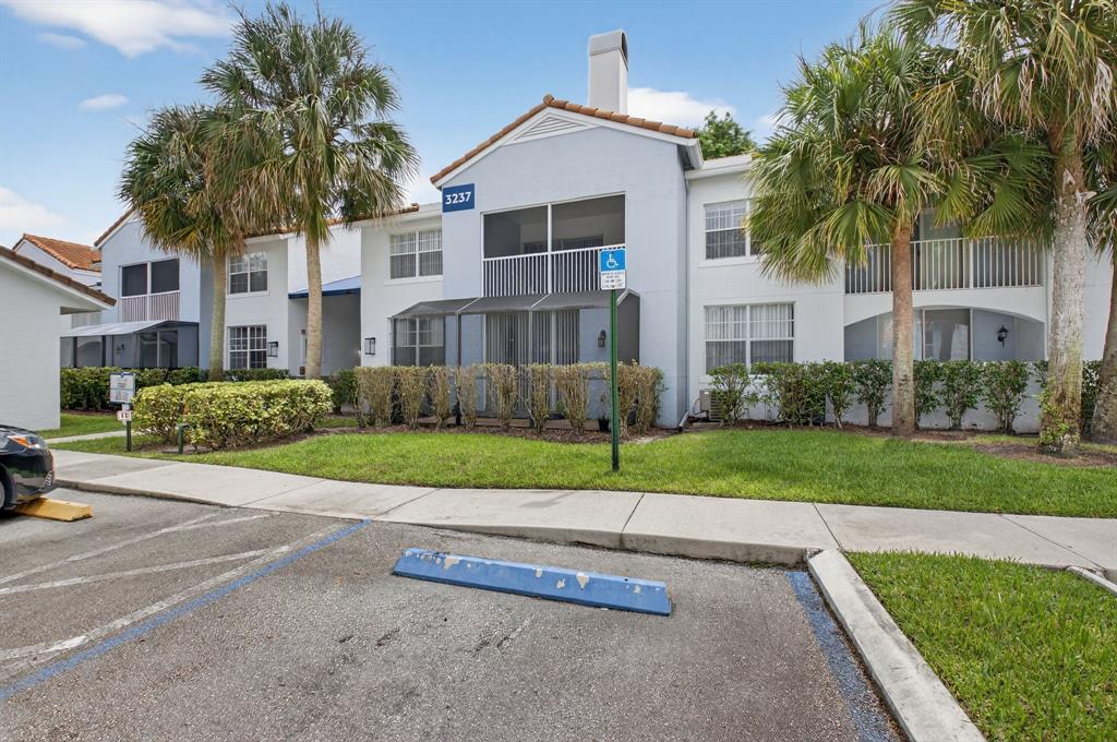 3237 Clint Moore Road, Unit 206 Boca Raton, FL 33496 - Photo 26 of 49 a view of a house with a yard and palm trees