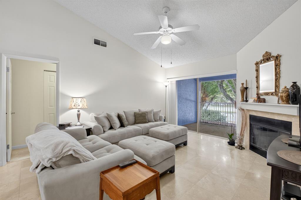 3237 Clint Moore Road, Unit 206 Boca Raton, FL 33496 - Photo 8 of 49 a living room with furniture and a fireplace