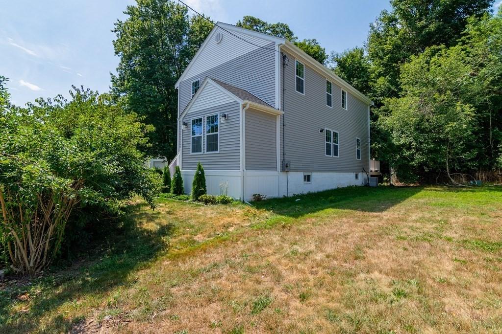 23 Amelian Road Randolph, MA 02368 - Photo 2 of 39 a backyard of a house with plants and large tree