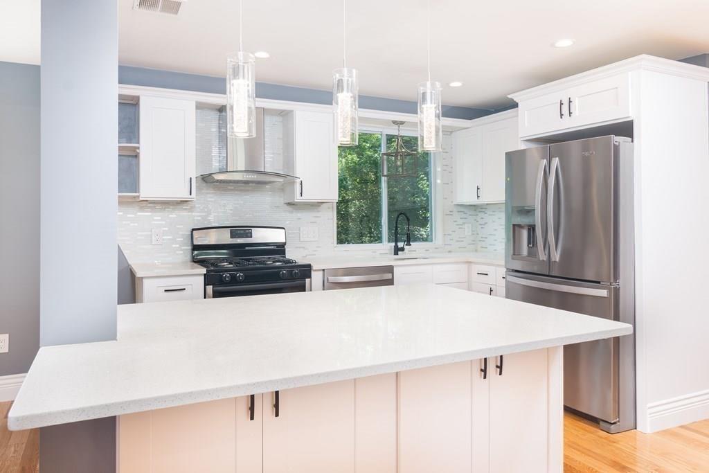 23 Amelian Road Randolph, MA 02368 - Photo 5 of 39 a kitchen with stainless steel appliances a sink and a refrigerator