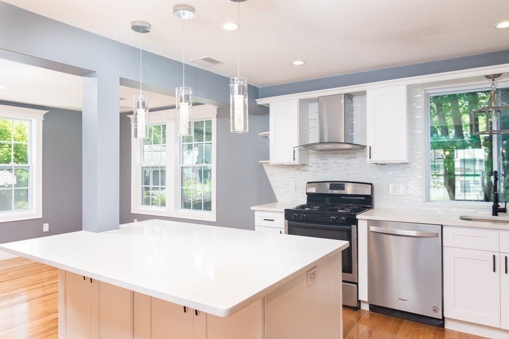 23 Amelian Road Randolph, MA 02368 - Photo 6 of 39 a kitchen with a stove a sink and a refrigerator