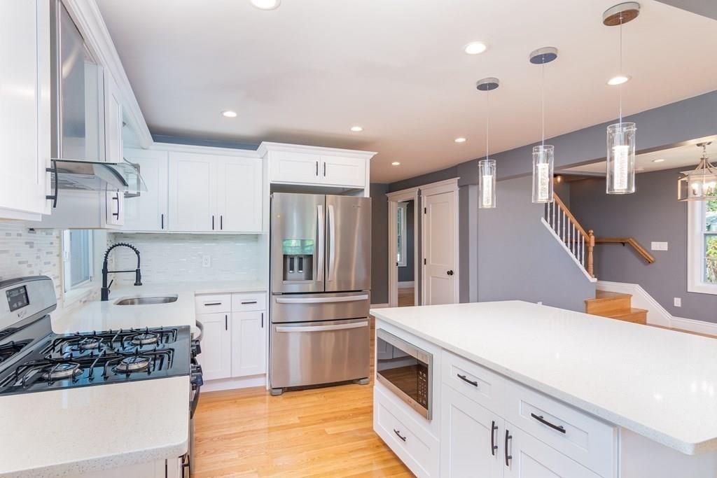 23 Amelian Road Randolph, MA 02368 - Photo 7 of 39 a kitchen with a sink a refrigerator and cabinets