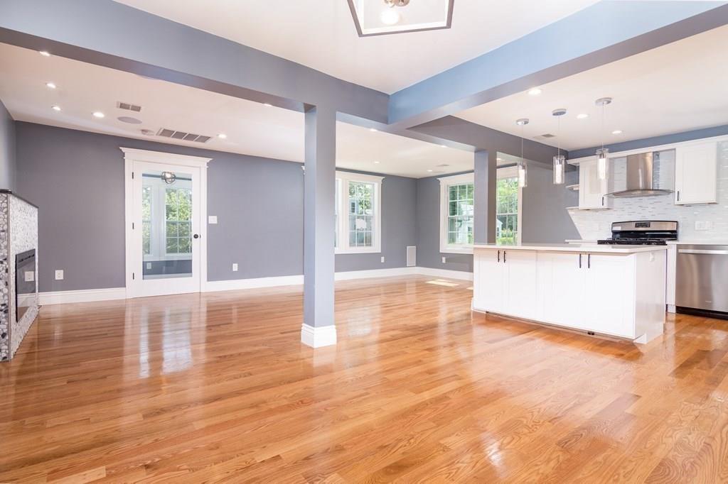 23 Amelian Road Randolph, MA 02368 - Photo 9 of 39 a large white kitchen with wooden floors and stainless steel appliances