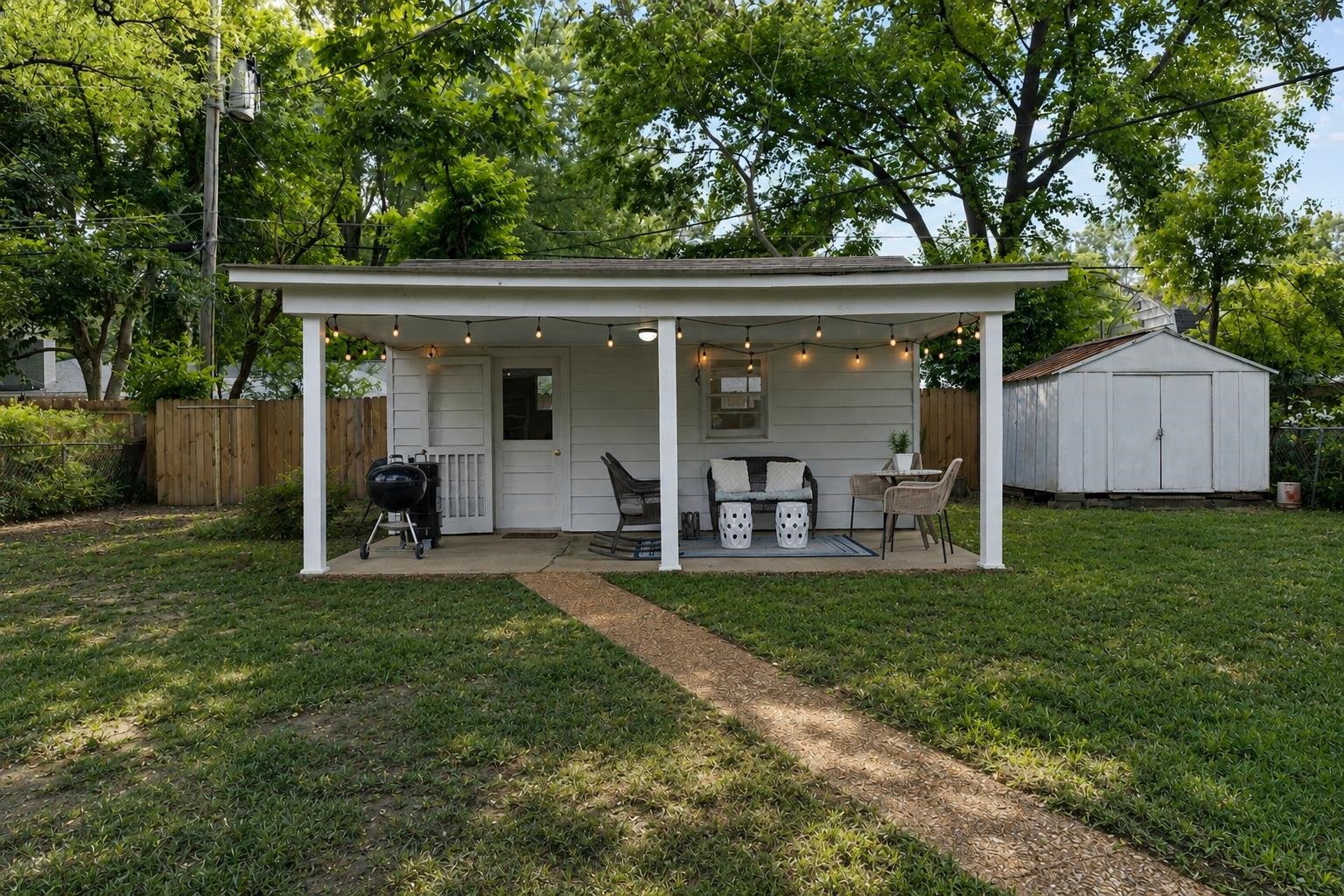 4491 Garnett Road Memphis, TN 38117 - Photo 23 of 32 Expansive green lawn with a concrete walkway leading to a covered patio