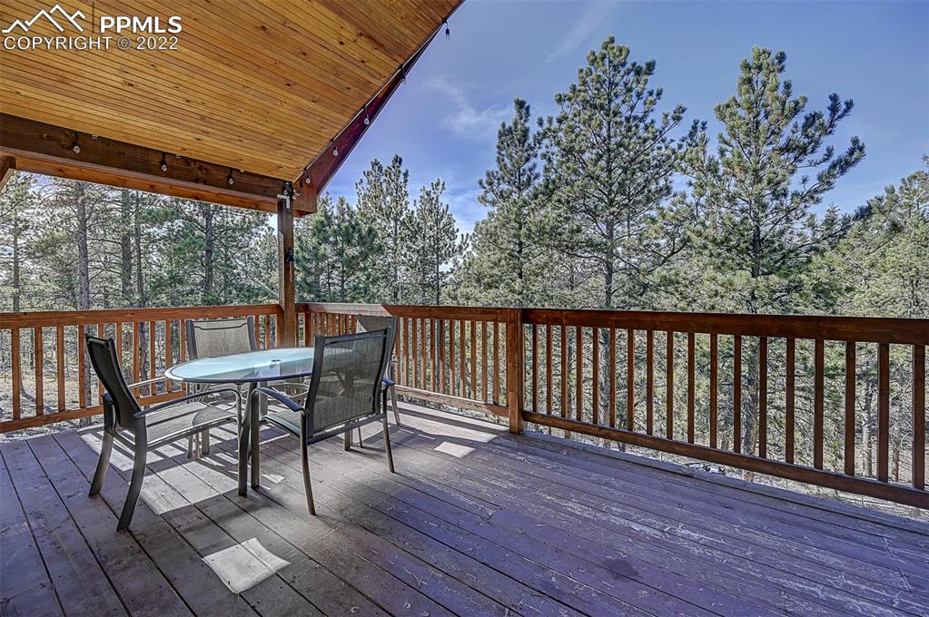 897 Fossil Creek Road Florissant, CO 80816 - Photo 23 of 40 a roof deck with table and chairs and wooden floor