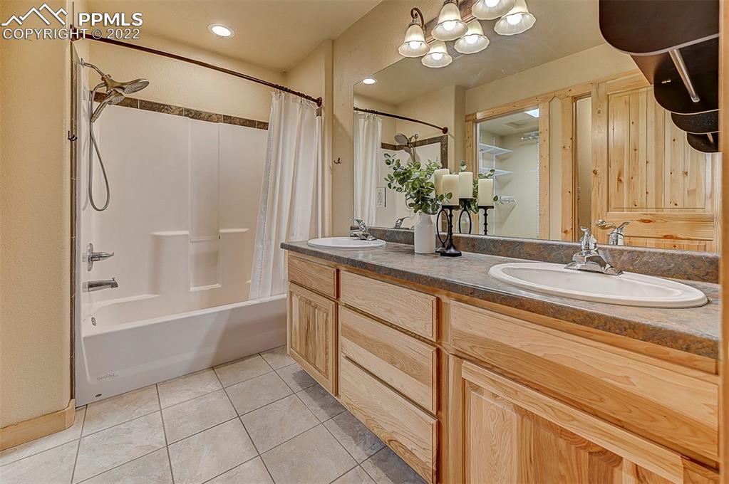 897 Fossil Creek Road Florissant, CO 80816 - Photo 9 of 40 a bathroom with a double vanity sink a mirror a bathtub and shower