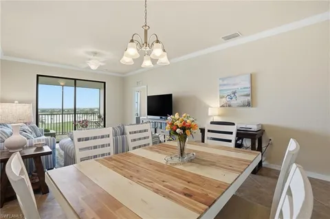 a bedroom with a bed a large window and a flat tv screen