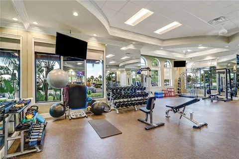 a room with gym equipment and a flat screen tv