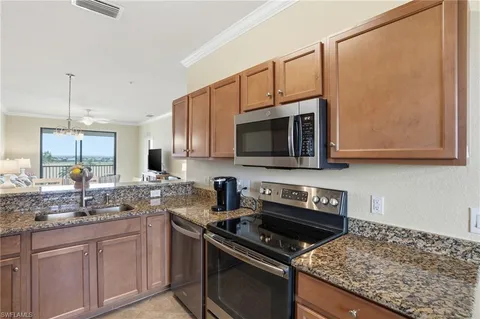 a kitchen with stainless steel appliances granite countertop a stove microwave and sink