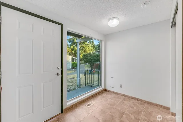 a view of an empty room with wooden floor and windows