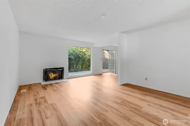 a view of a room with wooden floor and a fireplace