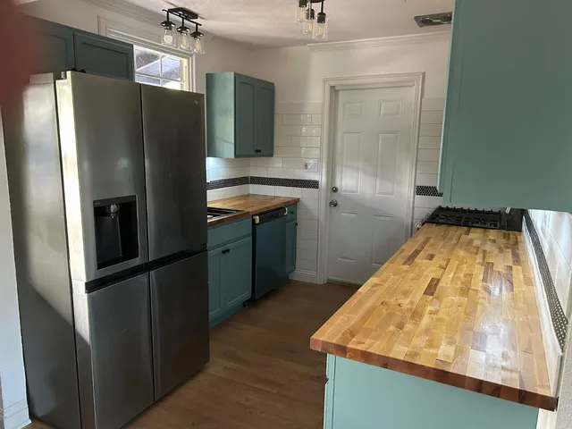a kitchen with granite countertop a stove and cabinets