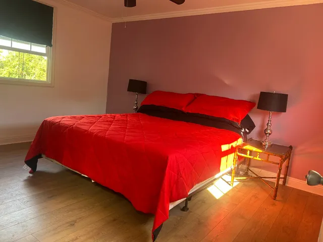 a view of an empty room with window and chandelier fan