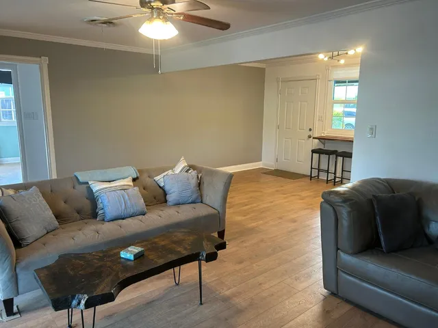 a kitchen with stainless steel appliances granite countertop a refrigerator a sink dishwasher a stove and a dining table with wooden floor