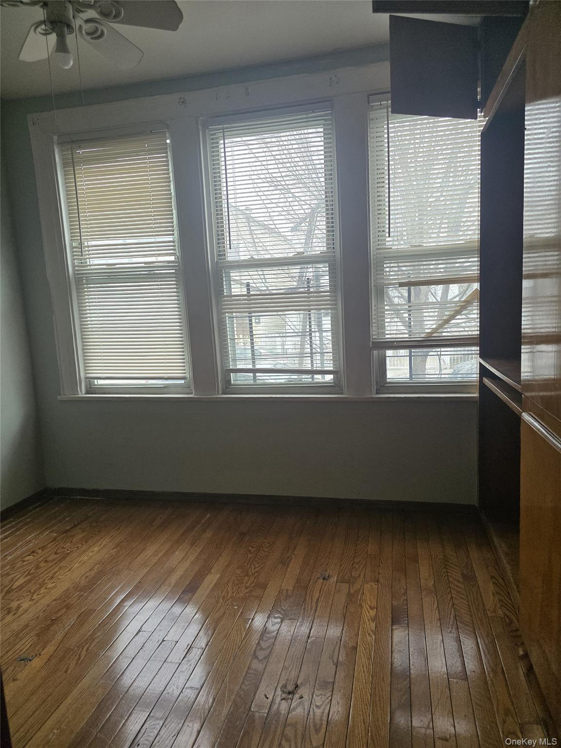 94-18 130th Street Queens, NY 11419 - Photo 1 of 9 an empty room with wooden floor and windows
