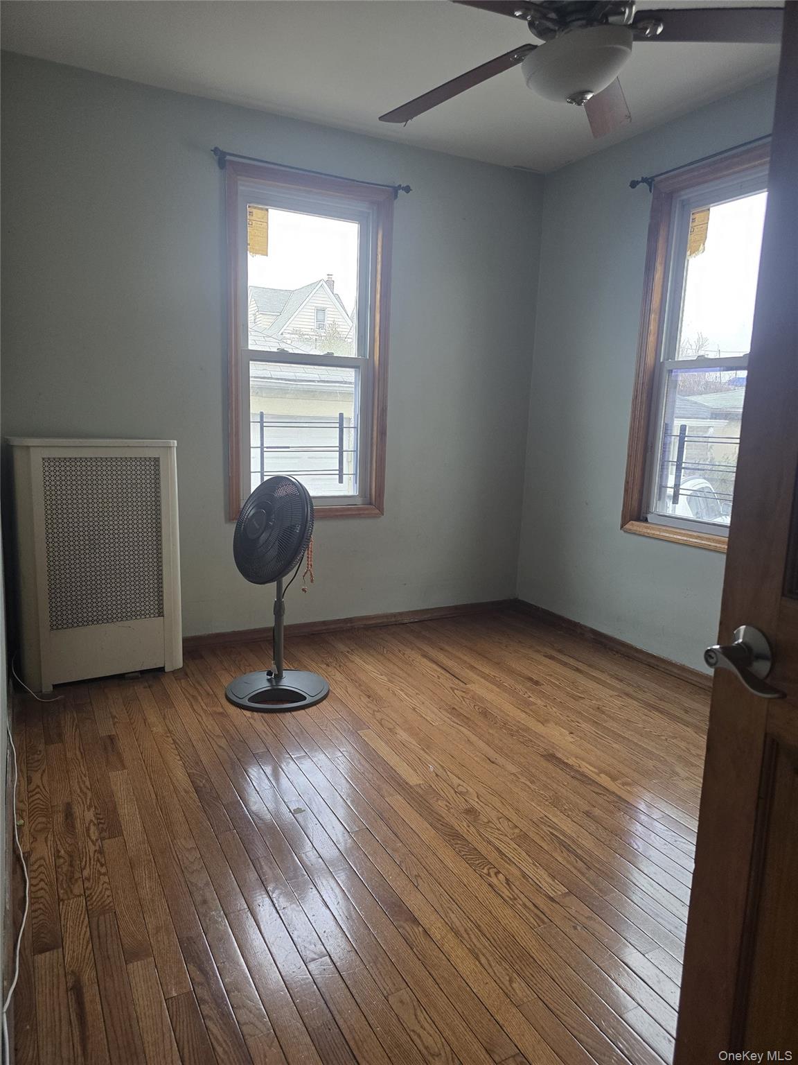 94-18 130th Street Queens, NY 11419 - Photo 7 of 9 a room with wooden floor and windows