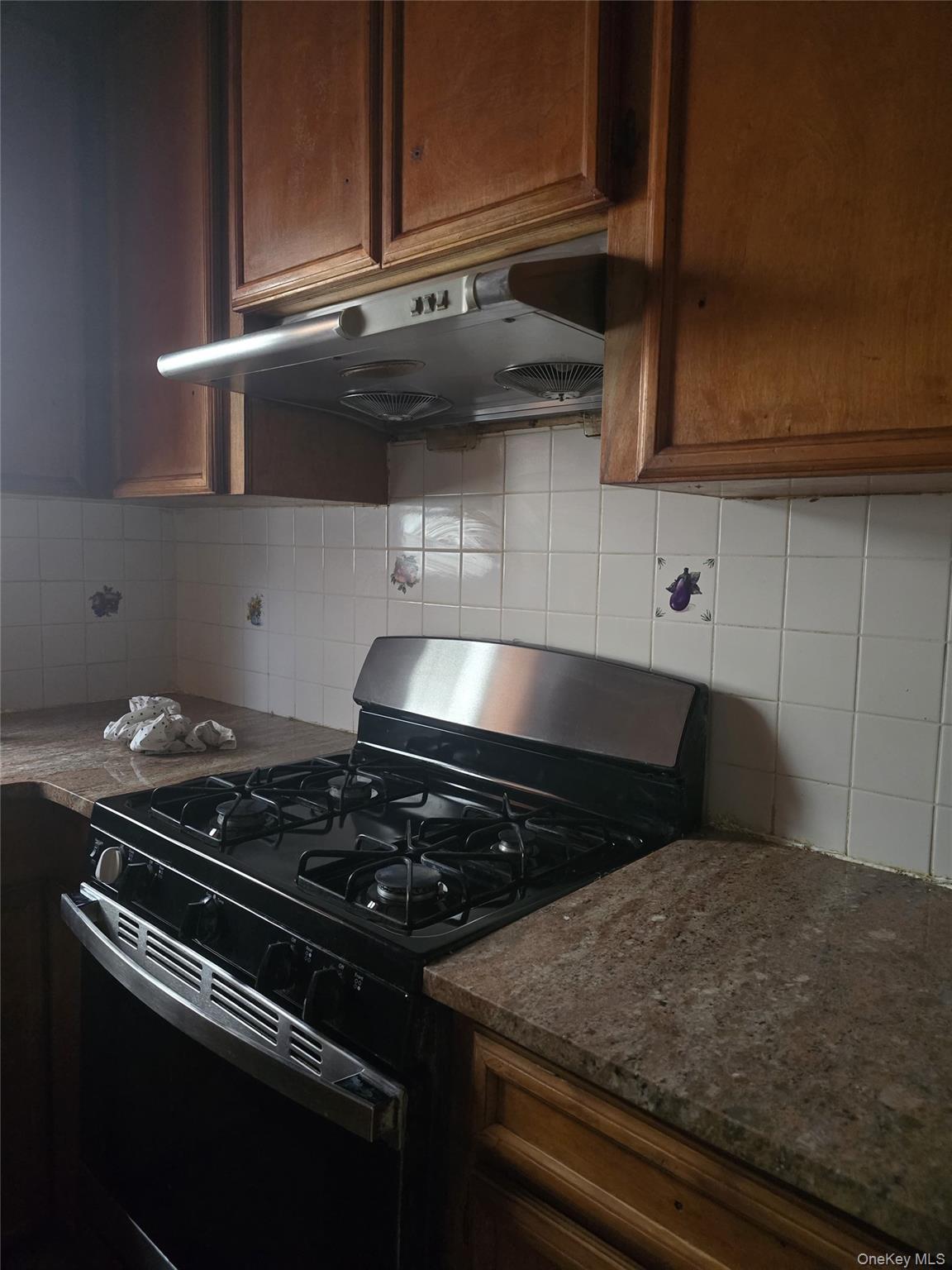 94-18 130th Street Queens, NY 11419 - Photo 8 of 9 a close view of a stove a microwave and cabinets