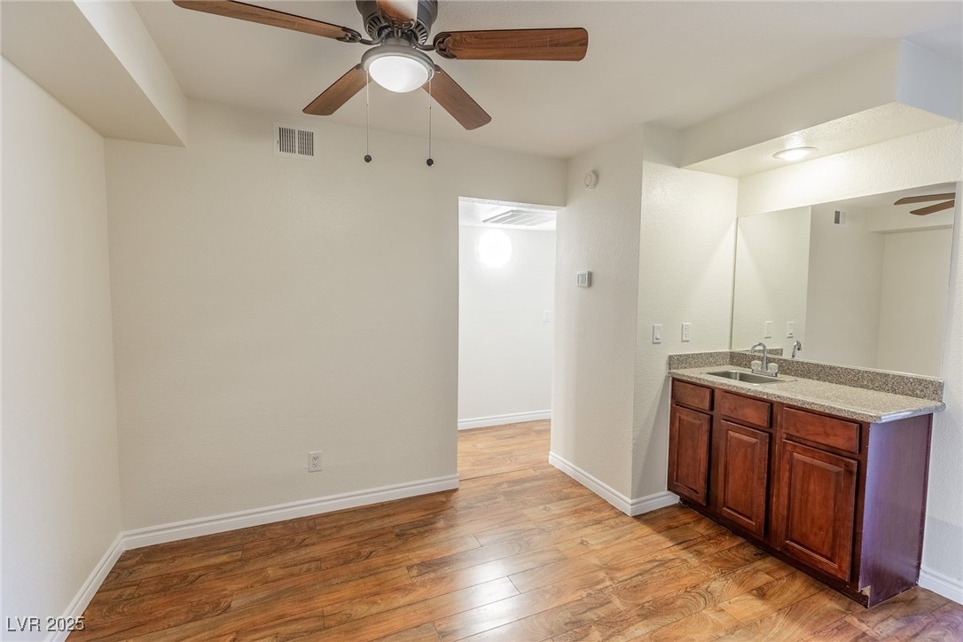 2451 North Rainbow Boulevard, Unit 1116 Las Vegas, NV 89108 - Photo 12 of 28 Bathroom featuring ceiling fan, vanity, and wood finished floors