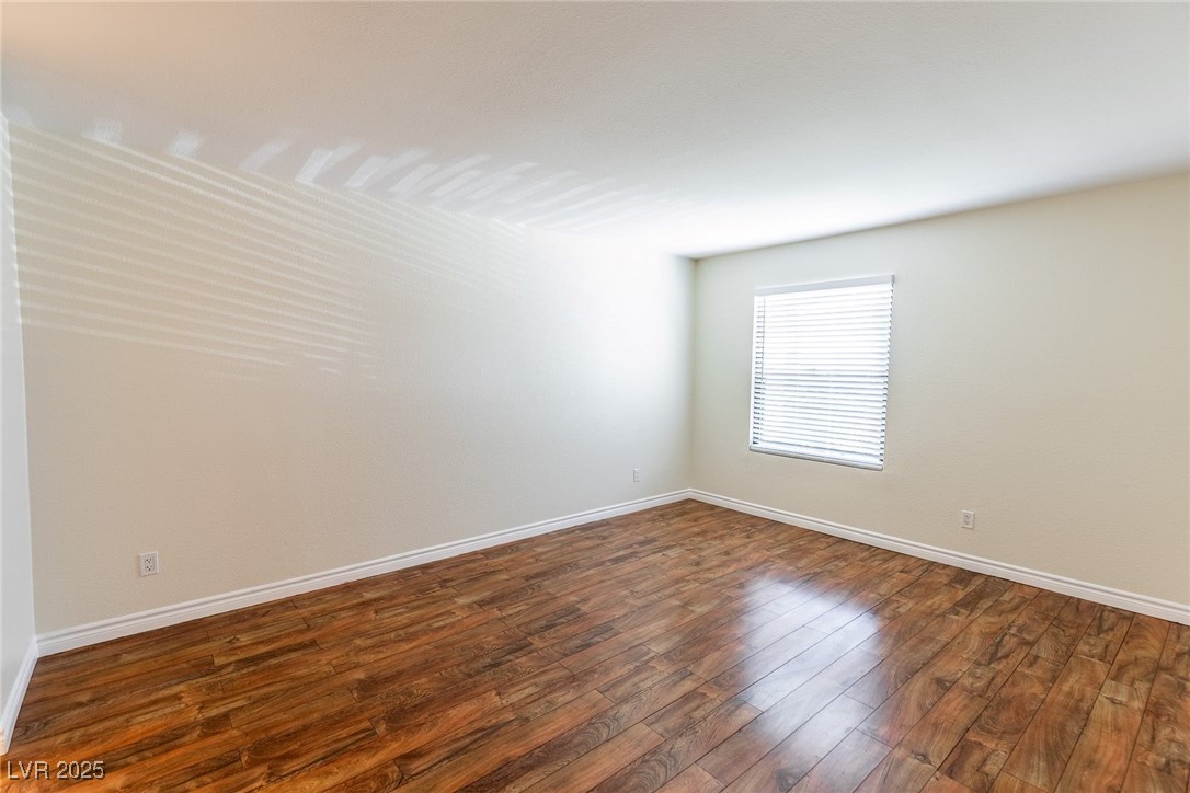 2451 North Rainbow Boulevard, Unit 1116 Las Vegas, NV 89108 - Photo 14 of 28 Unfurnished room featuring dark wood-style floors and baseboards