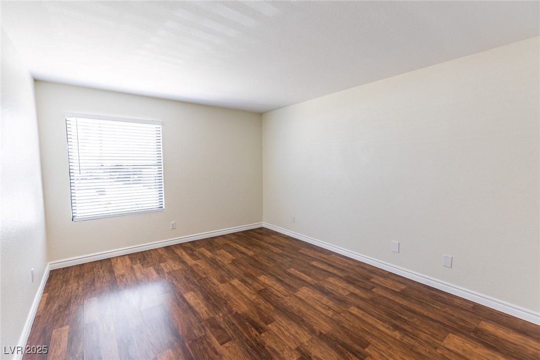 2451 North Rainbow Boulevard, Unit 1116 Las Vegas, NV 89108 - Photo 20 of 28 Empty room with dark wood finished floors and baseboards