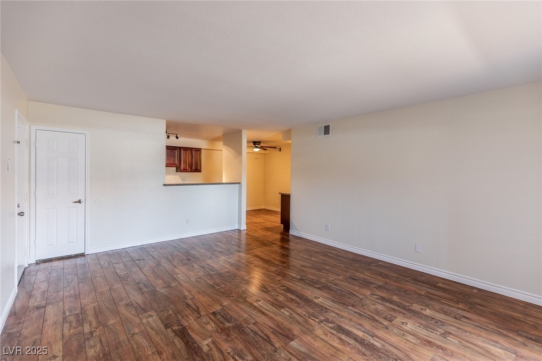 2451 North Rainbow Boulevard, Unit 1116 Las Vegas, NV 89108 - Photo 5 of 28 Unfurnished room with dark wood-type flooring and a ceiling fan