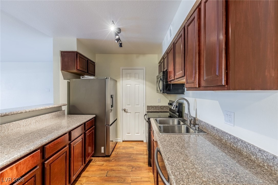2451 North Rainbow Boulevard, Unit 1116 Las Vegas, NV 89108 - Photo 9 of 28 Kitchen featuring stainless steel appliances and light wood-style flooring