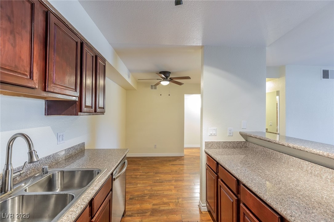 2451 North Rainbow Boulevard, Unit 1116 Las Vegas, NV 89108 - Photo 10 of 28 Kitchen featuring a ceiling fan, dark wood finished floors, and stainless steel dishwasher