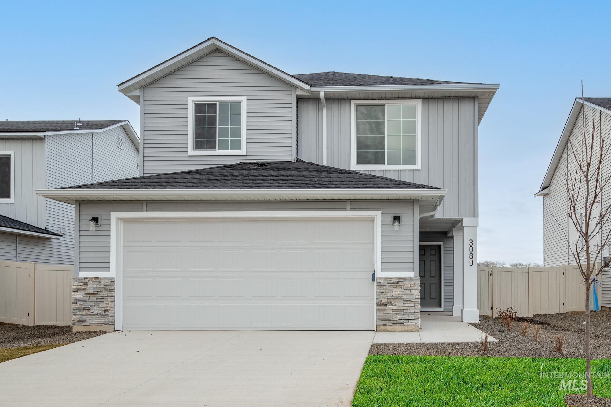 3089 South Maple Rnch Way Nampa, ID 83686 - Photo 1 of 22 View of front of house featuring stone siding, a shingled roof, concrete driveway, and board and batten siding