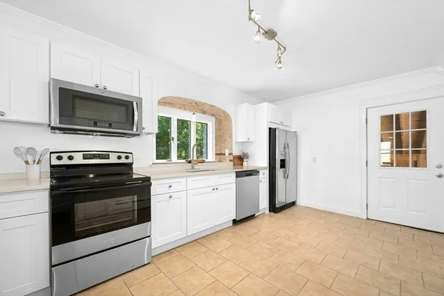 a kitchen with granite countertop a stove sink and refrigerator