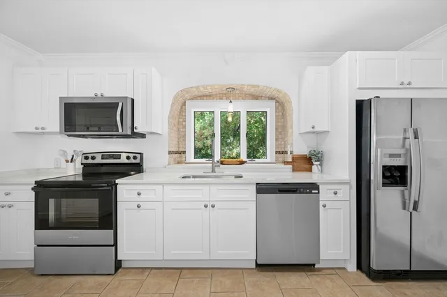 a kitchen with stainless steel appliances granite countertop a stove a sink and a refrigerator