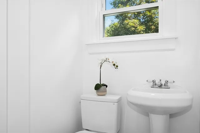 a bathroom with a sink a toilet and a mirror