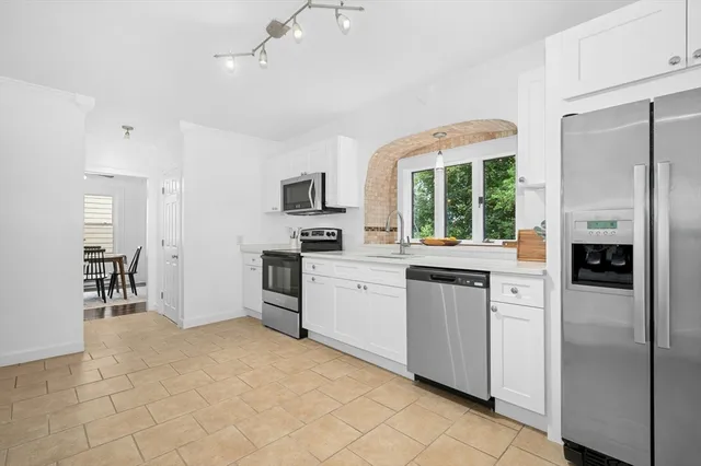 a kitchen with white cabinets and appliances