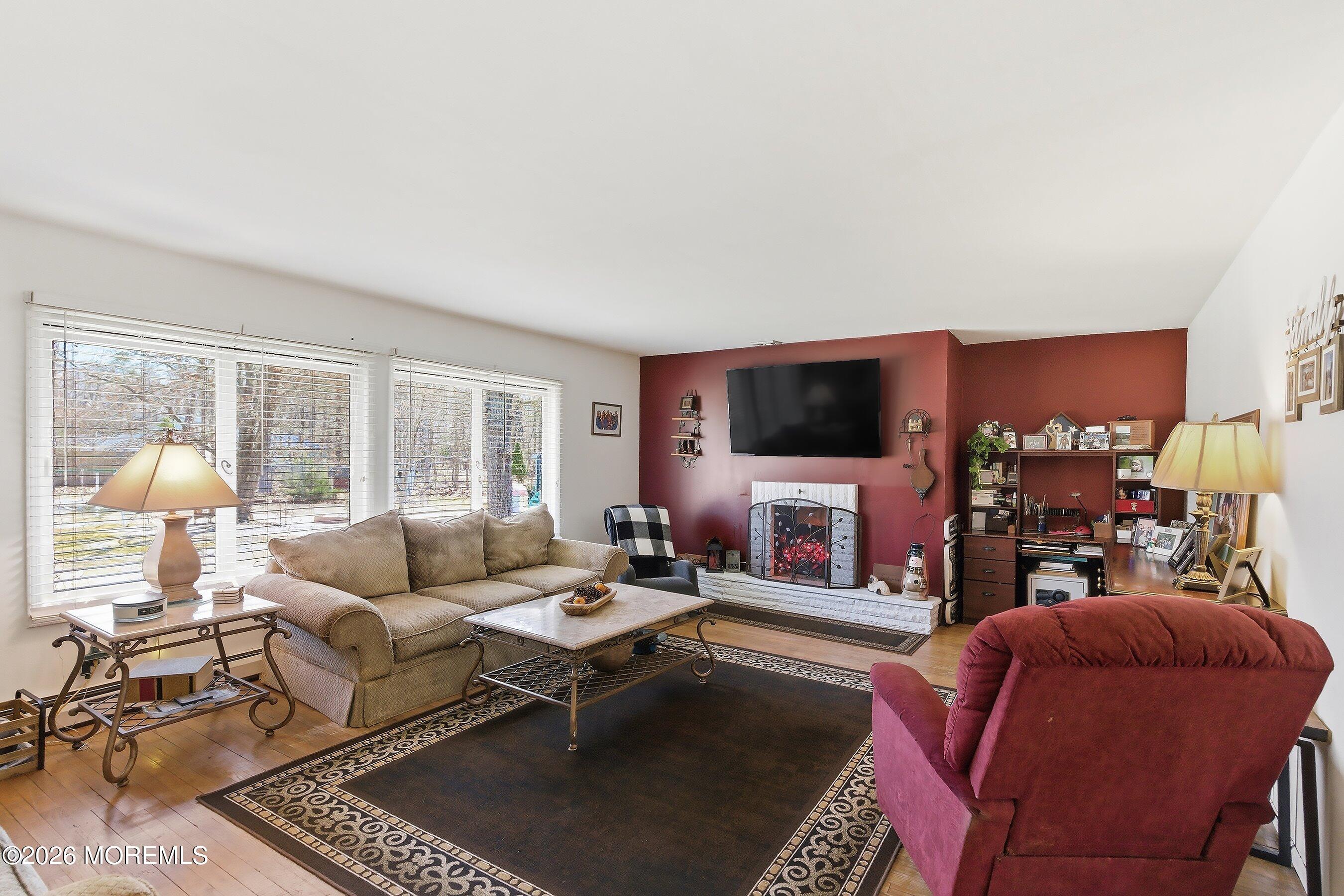 745 Oak Glen Road Howell, NJ 07731 - Photo 10 of 46 a living room with furniture a flat screen tv and a fireplace