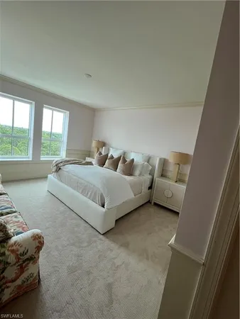 a bedroom with bed couch and window