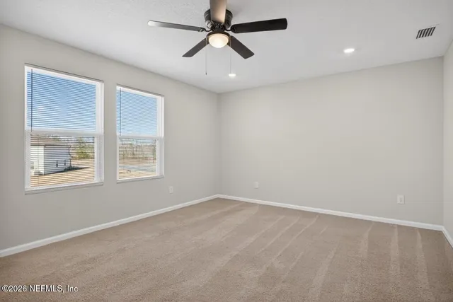 an empty room with a ceiling fan and a window