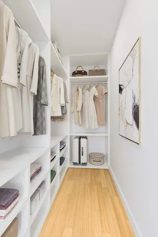 a view of walk in closet with clothes and shoes