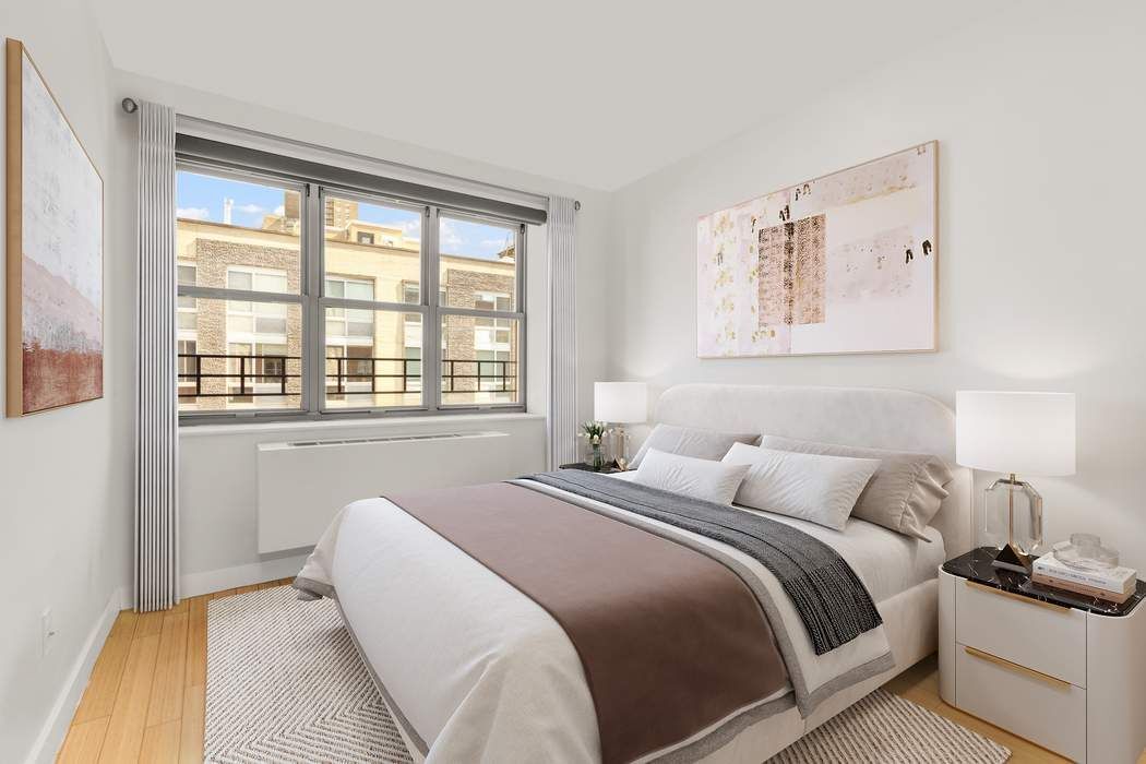 516 West 47th Street, Unit N6A Manhattan, NY 10036 - Photo 7 of 16 a bedroom with a bed and wooden floor