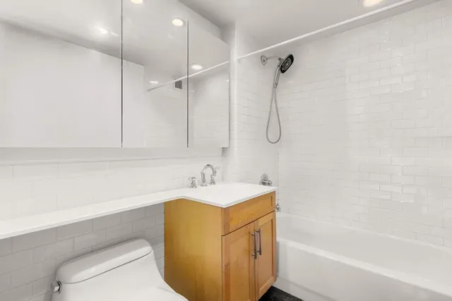a bathroom with a sink toilet vanity and shower