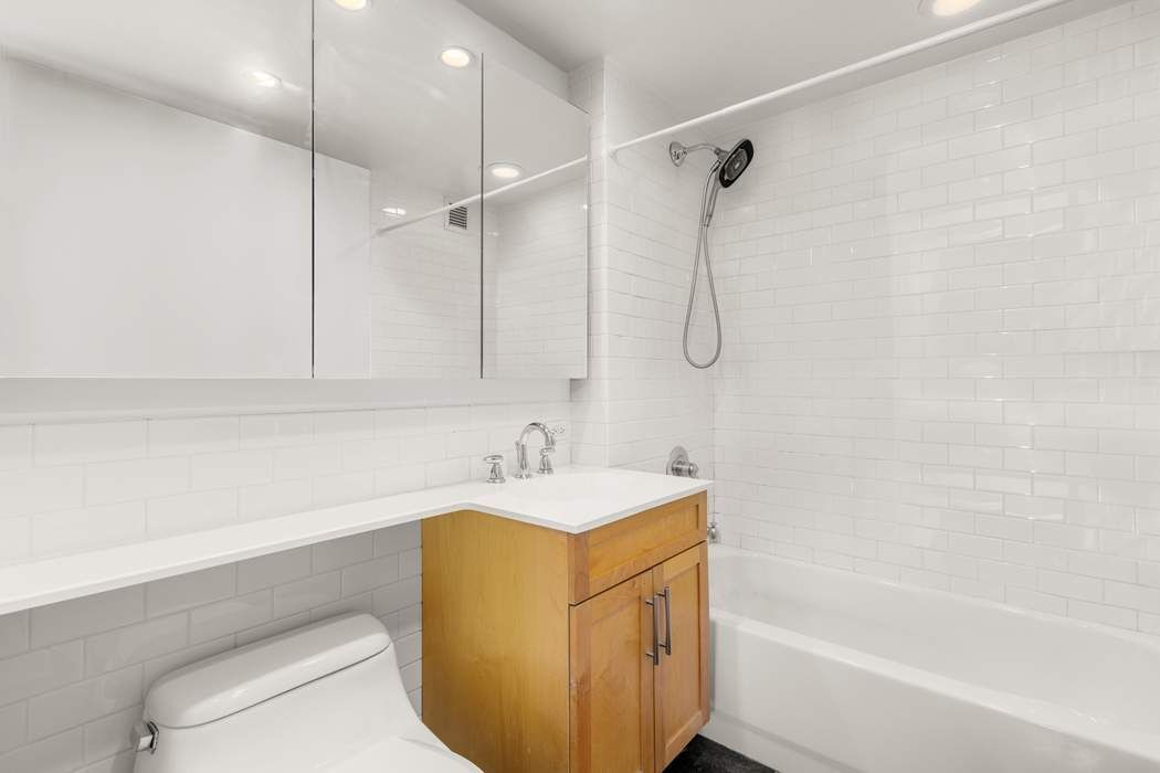 516 West 47th Street, Unit N6A Manhattan, NY 10036 - Photo 8 of 16 a bathroom with a sink toilet vanity and shower