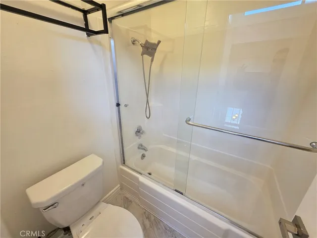 a bathroom with a toilet and a shower