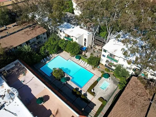 an aerial view of a tennis ground with a large pool