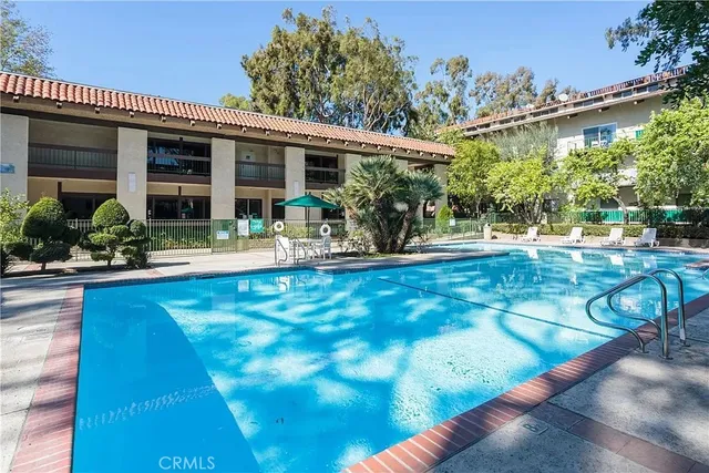 a house view with swimming pool in front of it