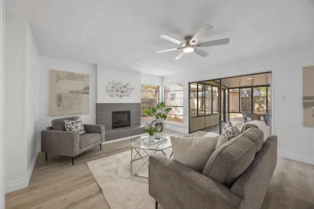 a living room with furniture a fireplace and a large window