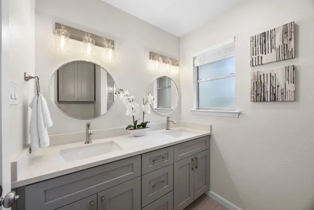 a bathroom with a double vanity sink and a mirror